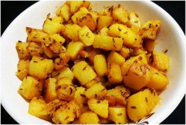 Vrat ke aloo with cumin, green chillies and coriander in a steel kadhai