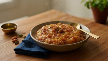 A bowl of glossy Singhare Atta Halwa garnished with almonds, cashews, and raisins, served as a Navratri vrat dessert on Indian Foods.